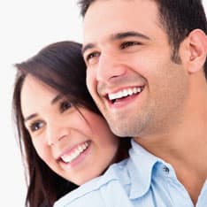 Donna e uomo che sorridono con denti bianchi e lucenti dopo la procedura professionale di pulizia dei denti eseguita nella clinica sotmatologica del Grand Turismo Dentale in Moldavia