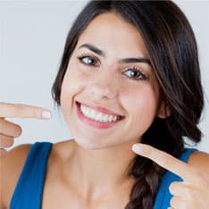 Donna che sorridono con denti bianchi e lucenti dopo la procedura professionale di pulizia dei denti eseguita nella clinica sotmatologica del Grand Turismo Dentale in Moldavia